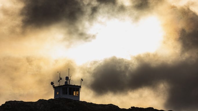 Light Through the Storm Clouds Silhouetted building beneath dramatic clouds and golden sunlight